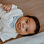 Jonathan is registered to the contest to win money with this photo: baby, infant, child, face, eyes, tongue, bow_tie, vest, clothing, lying_down, blanket, soft_texture, curious, portrait, indoors, cute, expression, skin, head, person