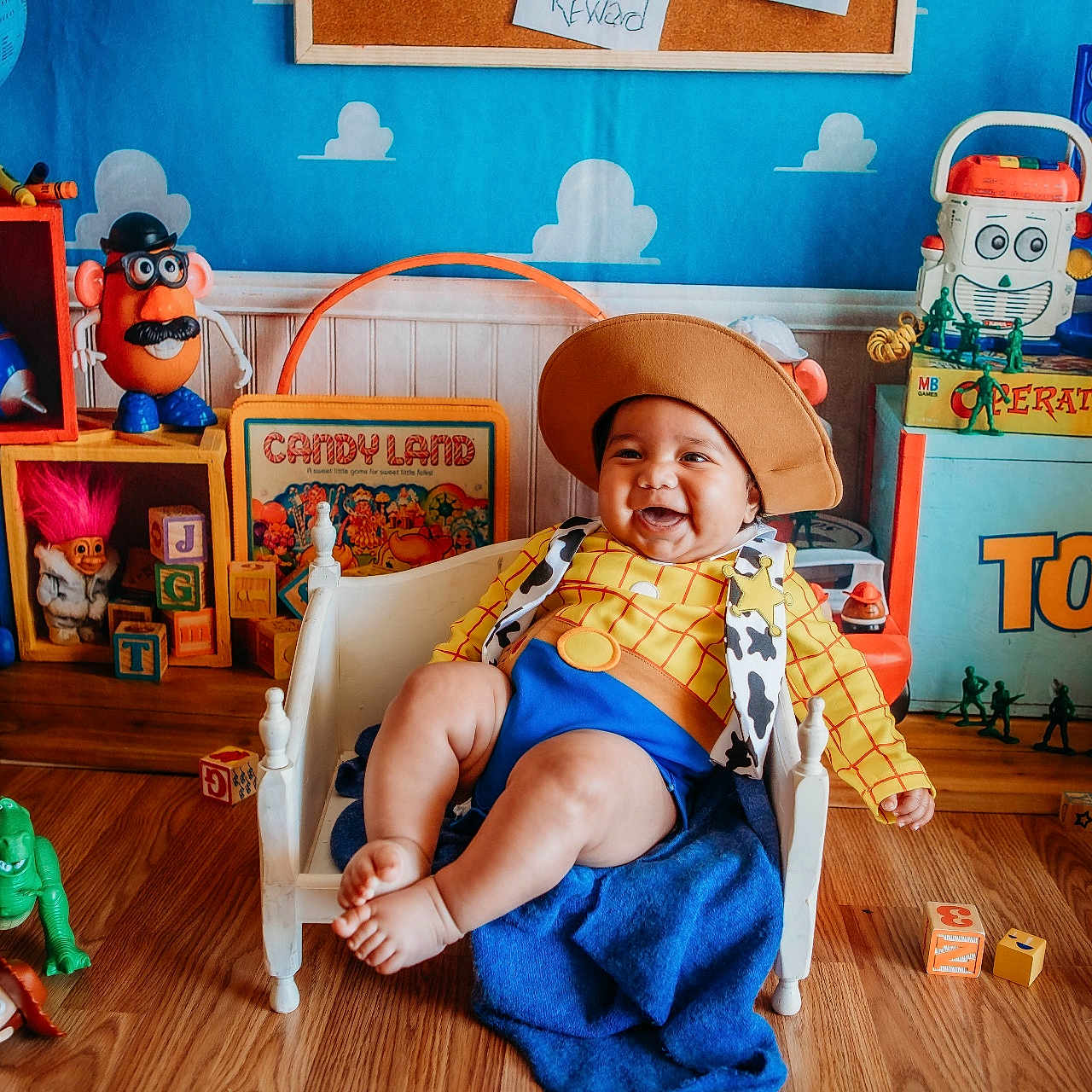 Jonathan joined the competition — help win amazing prizes! baby, blocks, blue_blanket, chair, child, colorful, costume, decor, doll, figurines, happy, hat, indoor, playful, playroom, smiling, toy_story_costume, toys, wooden_floor, woody