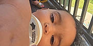Meilani is registered to the contest to win money with this photo: baby_bottle, balcony, child, close_up, curly_hair, daylight, face, footwear, grass, hand, leg, outdoor, person, plastic_cover, railing, sandals, shirt, skin, toddler, toy_wheel