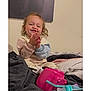Amira joined the competition — help win amazing prizes! baby_bottle, bed, blanket, casual, child, clapping, clothing, comfortable, curly_hair, cute, expression, happy, home, indoor, person, playtime, smiling, toddler, toy_phone, young_child