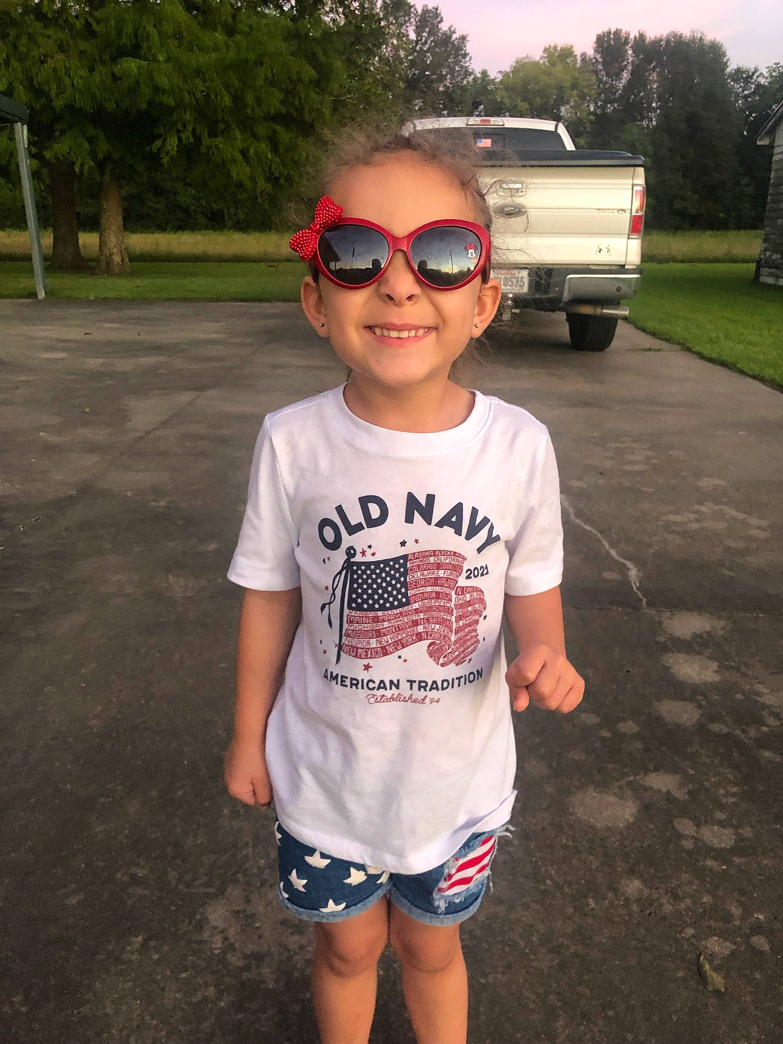 Madison joined the competition — help win amazing prizes! asphalt, black, eyewear, face, glasses, goggles, grass, happy, head, joy, person, plant, sleeve, smile, street_fashion, sunglasses, t_shirt, tree, vehicle, vision_care