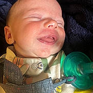 Bradley is registered to the contest to win money with this photo: baby, infant, face, close_up, pacifier, clothing, sleeping, smiling, mouth, skin, head, newborn, cute, child, young, expression, indoors, blanket, soft, peaceful