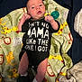 Bradley is registered to the contest to win money with this photo: baby, infant, blanket, animal_print, clothing, onesie, footwear, slippers, dinosaur, person, face, hand, lying_down, cute, expression, indoor, soft_texture, fabric, newborn, child