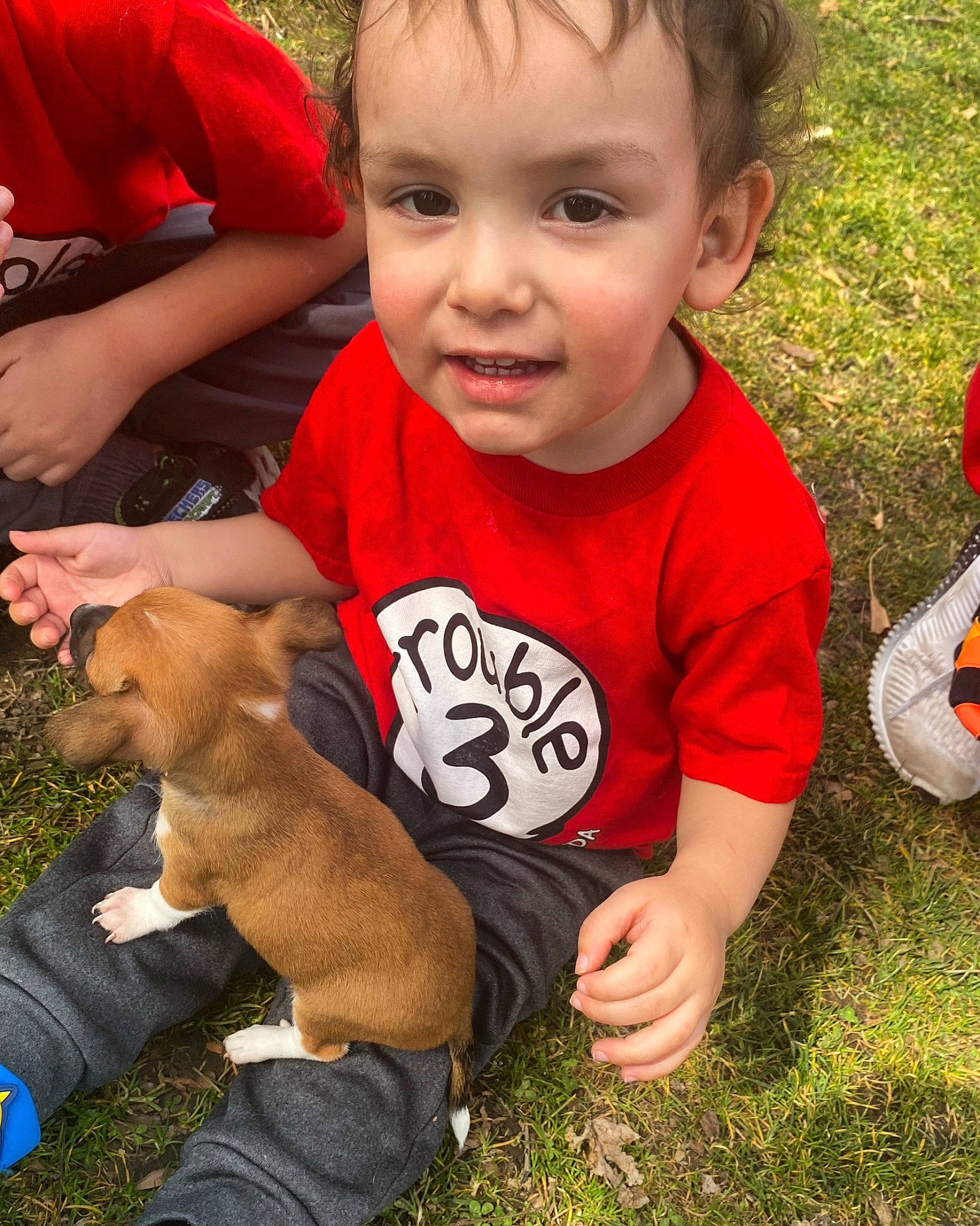 Adonis is registered to the contest to win money with this photo: arm, baby, baby_toddler_clothing, child, companion_dog, dog, finger, fun, gesture, grass, hand, happy, lawn, people_in_nature, person, plant, play, sitting, t_shirt, thumb