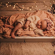 Mahyna participe au concours pour gagner de l'argent avec cette photo : baby, sleeping, teddy_bear, blanket, headband, knitwear, cozy, wooden_drawer, fairy_lights, soft_lighting, indoor, decor, floor, rug, flowers, peaceful, infant, portrait, cute, resting