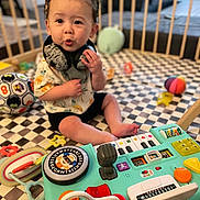 Miles joined the competition — help win amazing prizes! toddler, child, toy, playpen, activity_center, colorful, indoor, curly_hair, expression, playful, sitting, floor_mat, soccer_ball, infant, cute, baby, engaged, hand, clothing, headphones