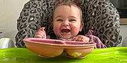 Charlotte joined the competition — help win amazing prizes! baby, high_chair, leopard_print, pink_plate, green_tray, messy_face, kitchen, food_chart, smiling, child, feeding, cute, infant, happy, table, wall_chart, utensils, domestic, portrait, indoor