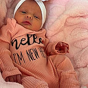 Mckenna is registered to the contest to win money with this photo: newborn, baby, infant, headband, flower, pink_blanket, cozy, sleepy, cute, portrait, clothing, soft_texture, small_hands, baby_sock, lying_down, indoor, closeup, child, person, resting