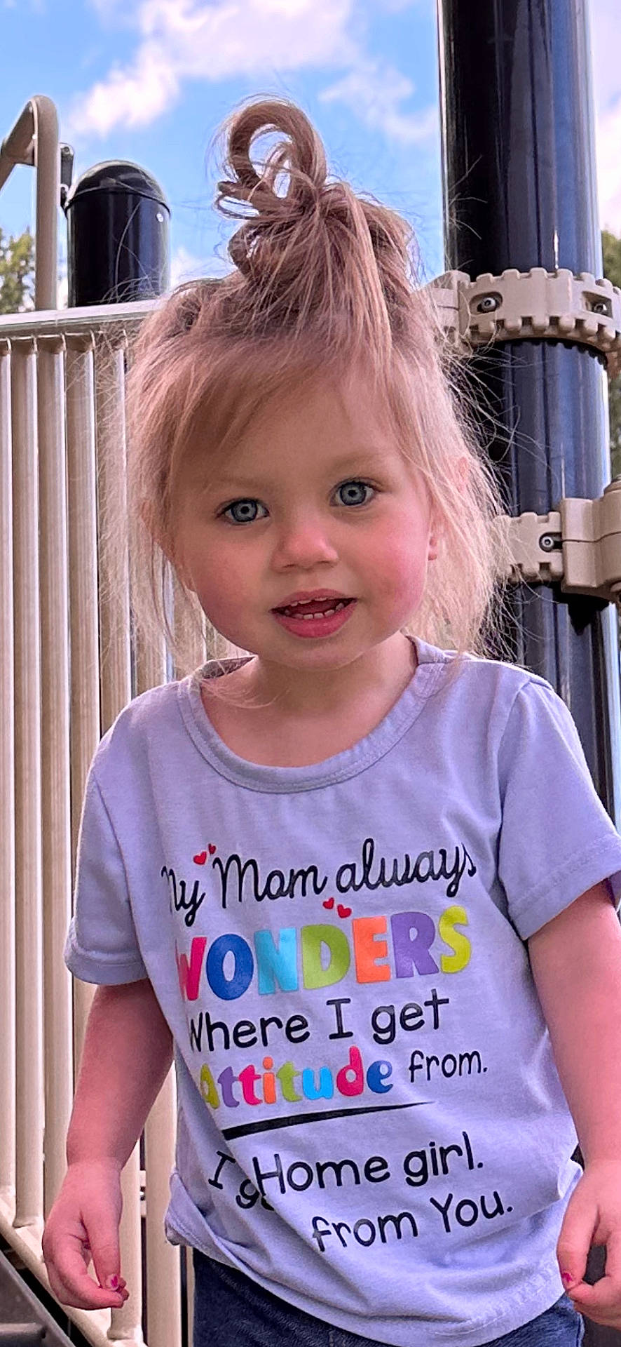 Sutton is registered to the contest to win money with this photo: blonde, bodypart, child, clothing, face, female, fence, finger, girl, hair, hand, head, outdoorplayarea, outdoors, person, photography, playarea, portrait, railing, t_shirt