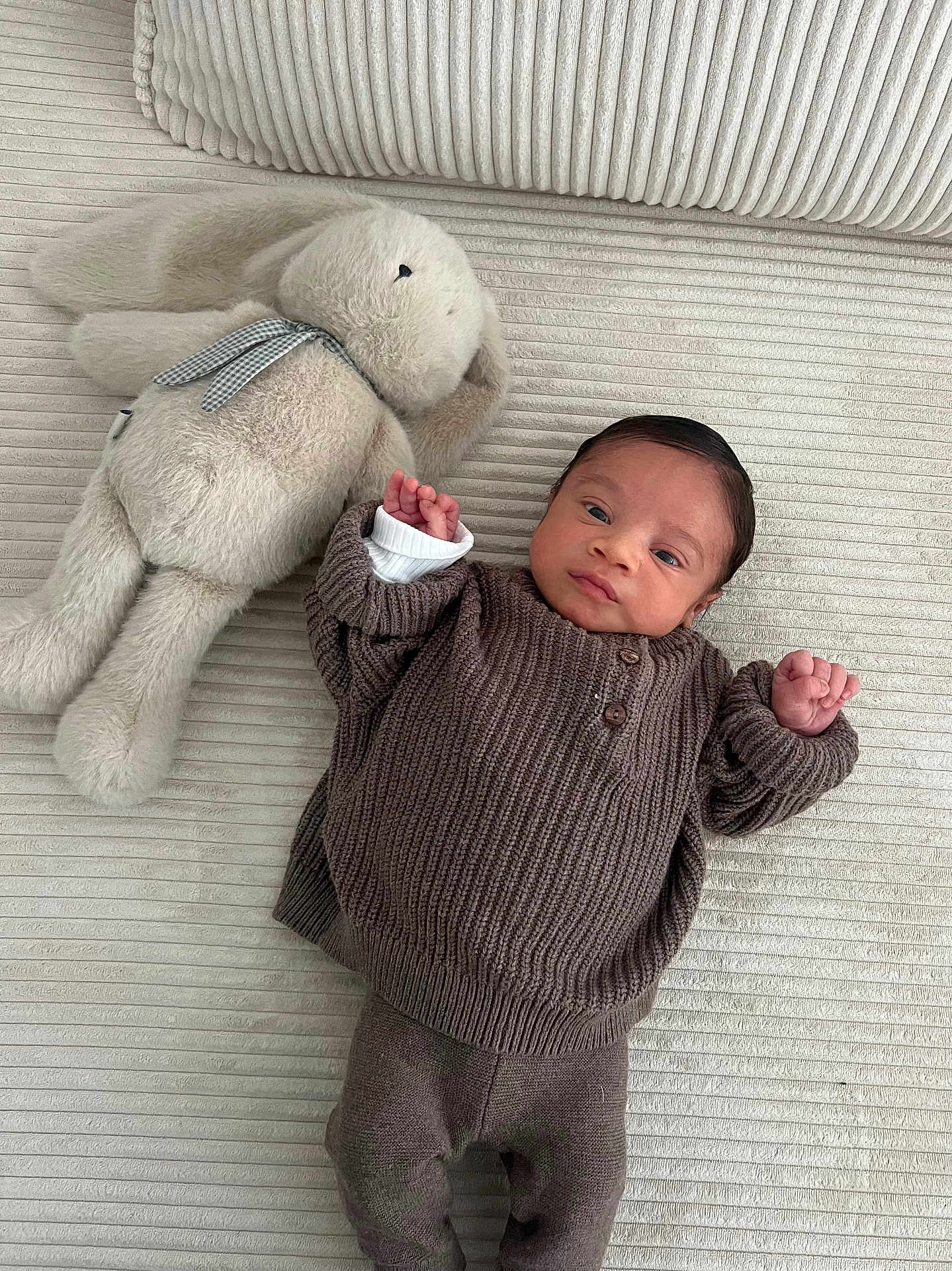 Isaïe a rejoint le concours — aidez-le/la à gagner de superbes lots ! baby, infant, stuffed_animal, bunny, plush_toy, knitwear, brown_clothing, soft_texture, cozy, laying_down, indoors, child, cute, newborn, portrait, toy, fabric, comfort, resting, small_hands