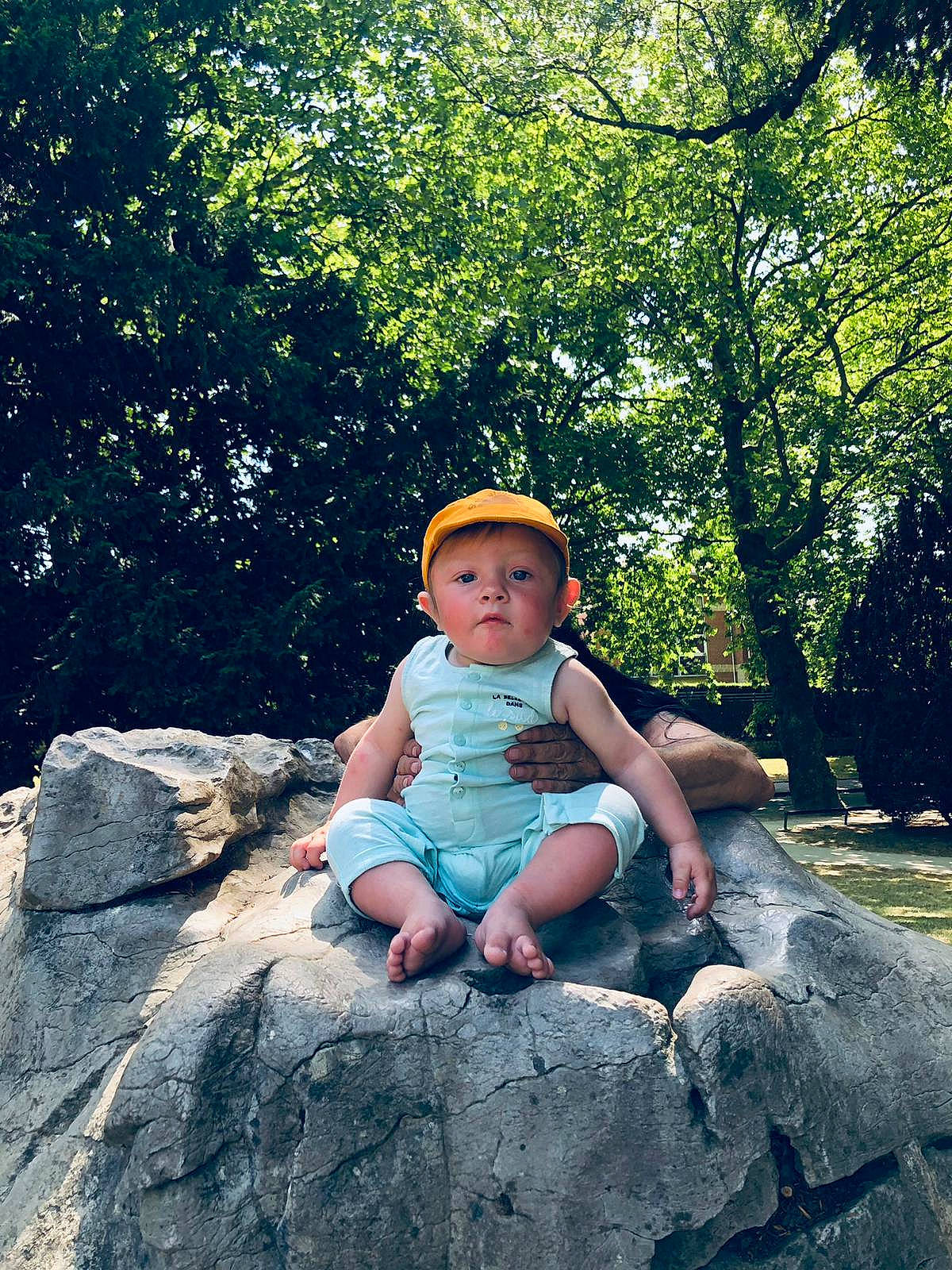 Ethan participe au concours pour gagner de l'argent avec cette photo : baby, baby_toddler_clothing, bedrock, child, electric_blue, fun, grass, happy, headwear, landscape, leaf, leisure, people_in_nature, person, plant, recreation, rock, sitting, soil, sun_hat