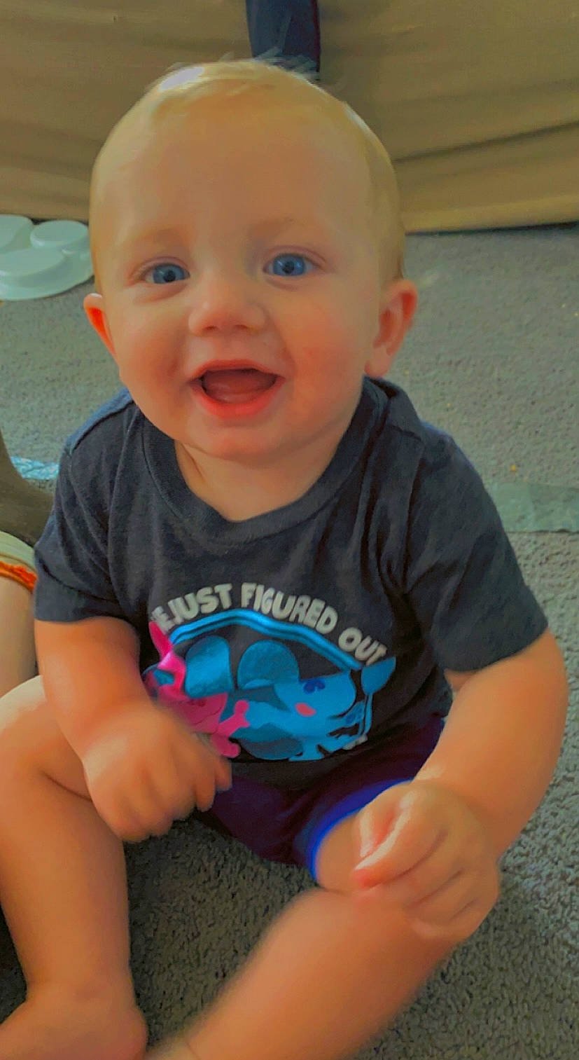 Rivers is registered to the contest to win money with this photo: arm, baby_toddler_clothing, cheek, chin, eye, hair, happy, human_body, iris, joint, mouth, muscle, neck, nose, organ, person, shoulder, skin, sleeve, smile