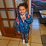 Serena participe au concours pour gagner de l'argent avec cette photo : child, smiling, indoor, jacket, backpack, door, floor_tiles, sneakers, leggings, happy, person, young, hair, patterned_clothing, furniture, window, couch, table, home, casual