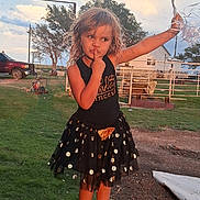 Lani is registered to the contest to win money with this photo: child, girl, balloons, skirt, shoes, outdoor, grass, farm, fence, tree, sky, clouds, sunset, metal, pose, standing, playful, casual_clothing, expression, daytime