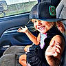 Lani joined the competition — help win amazing prizes! child, smiling, baseball_cap, car_seat, window, vehicle_interior, happy, girl, clothing, seat, playful, portrait, casual, young, person, hat, seatbelt, daylight, fun, inside_car