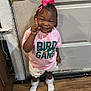 toddler, child, girl, indoor, wooden_floor, pink_bow, hair_accessory, tshirt, shorts, socks, smiling, pointing, door, doorknob, floor, clothing, person, cute, standing, happy