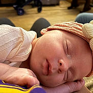 Bailee Rockholt is registered to the contest to win money with this photo: baby, sleeping, headband, flower, pink, newborn, infant, closeup, peaceful, soft, skin, hand, resting, indoors, cozy, warm_light, portrait, cute, child, peaceful_sleep