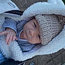 baby, beanie, blanket, bundled, child, closeup, cozy, cute, expression, face, hand, hood, infant, jacket, knit_hat, outdoor, pavement, portrait, stroller, wheel