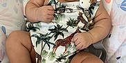 Cataleya joined the competition — help win amazing prizes! baby, infant, child, curly_hair, tropical_outfit, giraffe_print, palm_trees, pacifier_clip, cushioned_seat, floral_pattern, pastel_colors, chubby_cheeks, barefoot, cute, indoors, portrait, relaxed, looking_at_camera, skin, baby_clothing