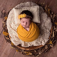 énola participe au concours pour gagner de l'argent avec cette photo : newborn, baby, sleeping, swaddled, yellow_wrap, headband, flower, pillow, lace, cushion, wooden_bowl, dried_flowers, wooden_floor, portrait, indoor, peaceful, cute, infant, cozy, soft_lighting