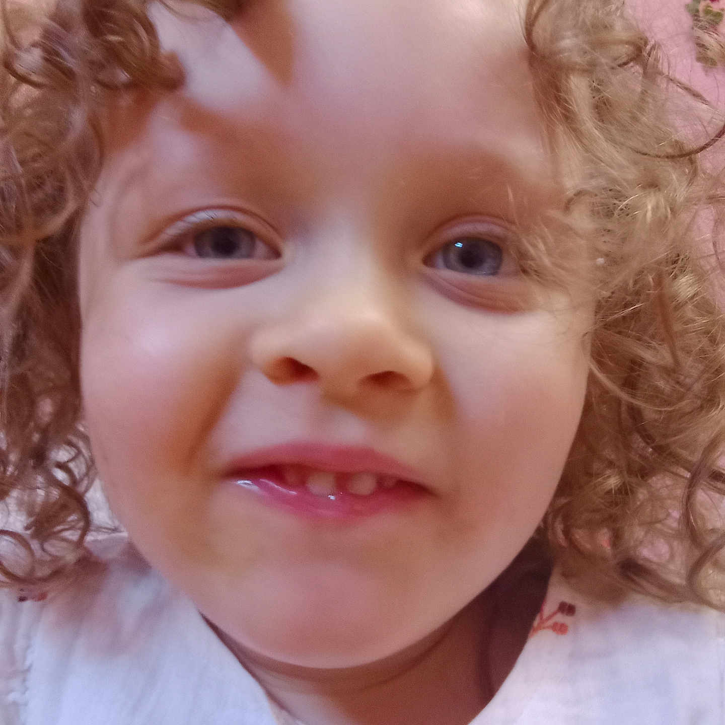Harper joined the competition — help win amazing prizes! child, toddler, curly_hair, face, smile, closeup, portrait, white_clothing, happy, eyes, skin, indoors, pink_background, baby, cute, expression, person, head, young, innocent