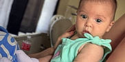 Maielynn is registered to the contest to win money with this photo: arm, baby, casual, clock, closeup, clothing, curtains, expression, face, furniture, holding, home, indoor, infant, legs, light, person, relaxing, skin, socks