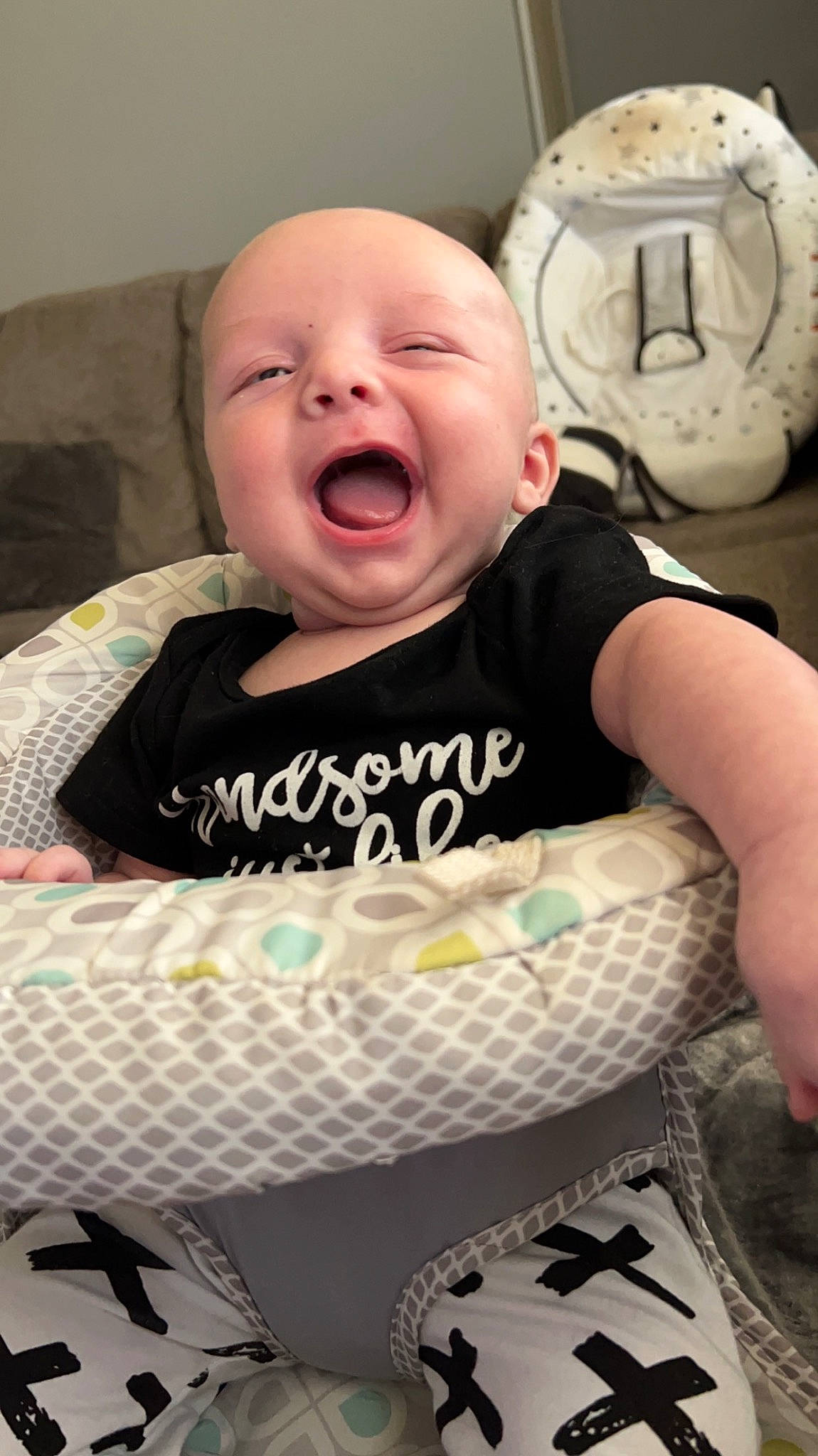 Beau is registered to the contest to win money with this photo: baby, baby_products, baby_toddler_clothing, cheek, child, comfort, cool, facial_expression, happy, linens, mammal, mouth, pattern, person, sitting, skin, sleeve, smile, textile, toddler