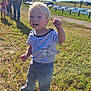 toddler, child, outdoor, grass, sunny, blue_sky, clouds, striped_shirt, shark_design, celebration, people, adult, casual_clothing, footwear, daylight, nature, field, happy, portrait, fun