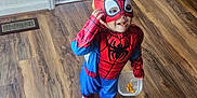 Haigen joined the competition — help win amazing prizes! child, costume, spiderman, mask, snack, barefoot, floor, wood_floor, plastic_container, indoor, boots, backpack, door, light, smile, food, candid, home, playful, young_child