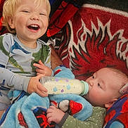 Timothy joined the competition — help win amazing prizes! baby, toddler, bottle, feeding, blanket, smile, child, infant, happy, clothing, red, blue, pattern, holding, bed, cute, portrait, indoor, cozy, family