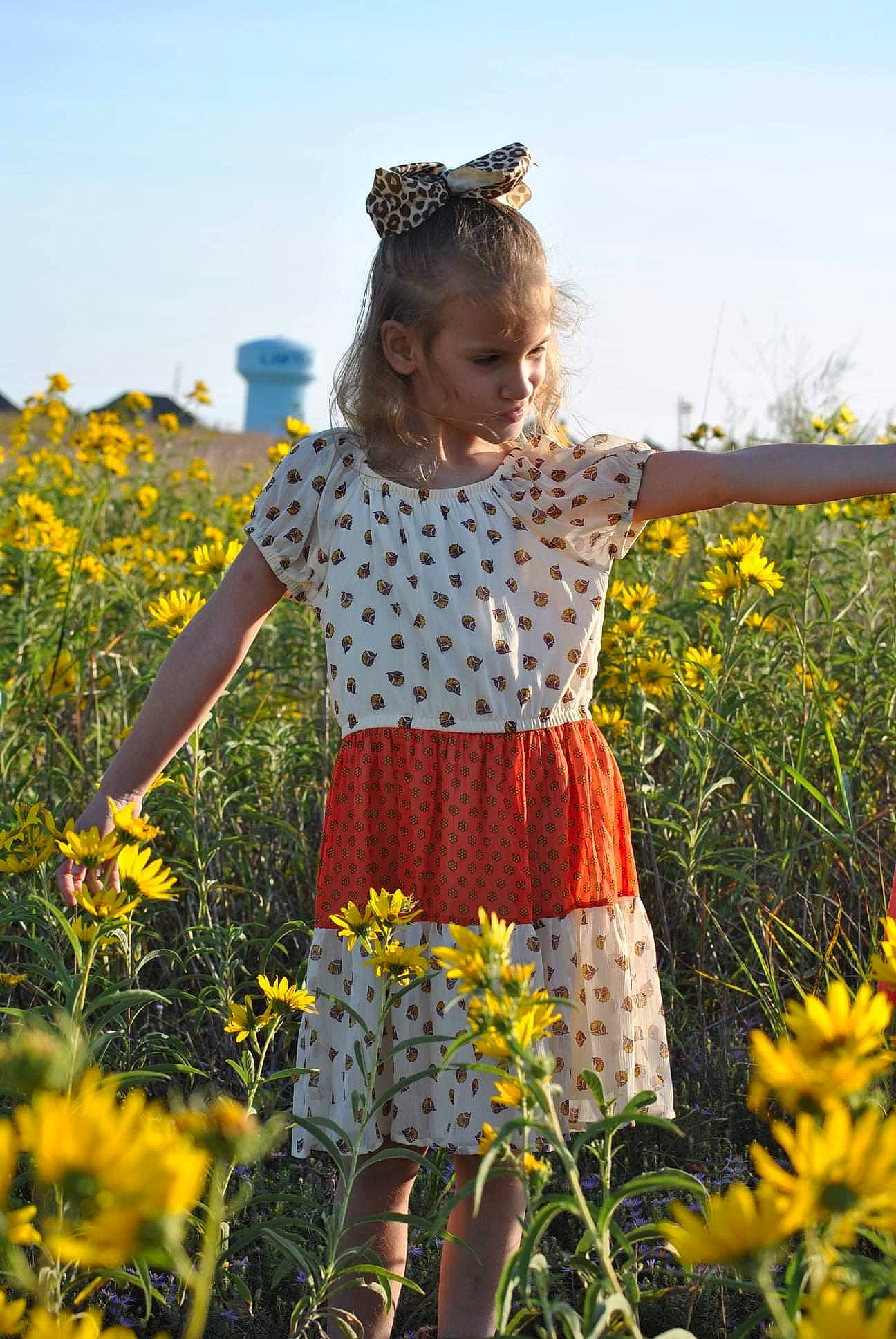 Rosalina is registered to the contest to win money with this photo: agriculture, baby_toddler_clothing, daisy_family, day_dress, dress, field, flower, flowering_plant, meadow, one_piece_garment, people_in_nature, person, petal, plant, prairie, spring, summer, sunglasses, toddler, wildflower