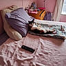 bed, blanket, calico_cat, cat, cozy, curtains, domestic, dresser, feline, furniture, indoor, pet, pillow, pink_wall, purple_pillow, relaxed, remote_control, room, soft_light, window