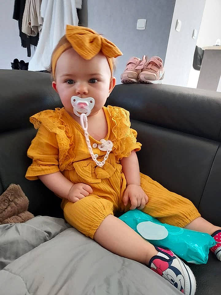 Lily Rose participe au concours pour gagner de l'argent avec cette photo : baby, baby_toddler_clothing, chair, child, comfort, couch, face, finger, fun, happy, hat, human_leg, knee, lap, person, room, sitting, skin, textile, thigh