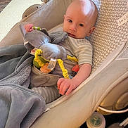 Wyatt joined the competition — help win amazing prizes! baby, infant, baby_rocker, stuffed_animal, blanket, clothing, face, head, person, indoor, baby_bottle, toy, seat, comfort, expression, baby_gear, floor, carpet, home, child