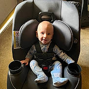 Wyatt joined the competition — help win amazing prizes! baby, car_seat, child, smiling, seatbelt, indoor, footwear, socks, black, plastic, door, floor, car_seat_cup_holder, head_support, clothing, infant, person, safety, cosco_kids, happy