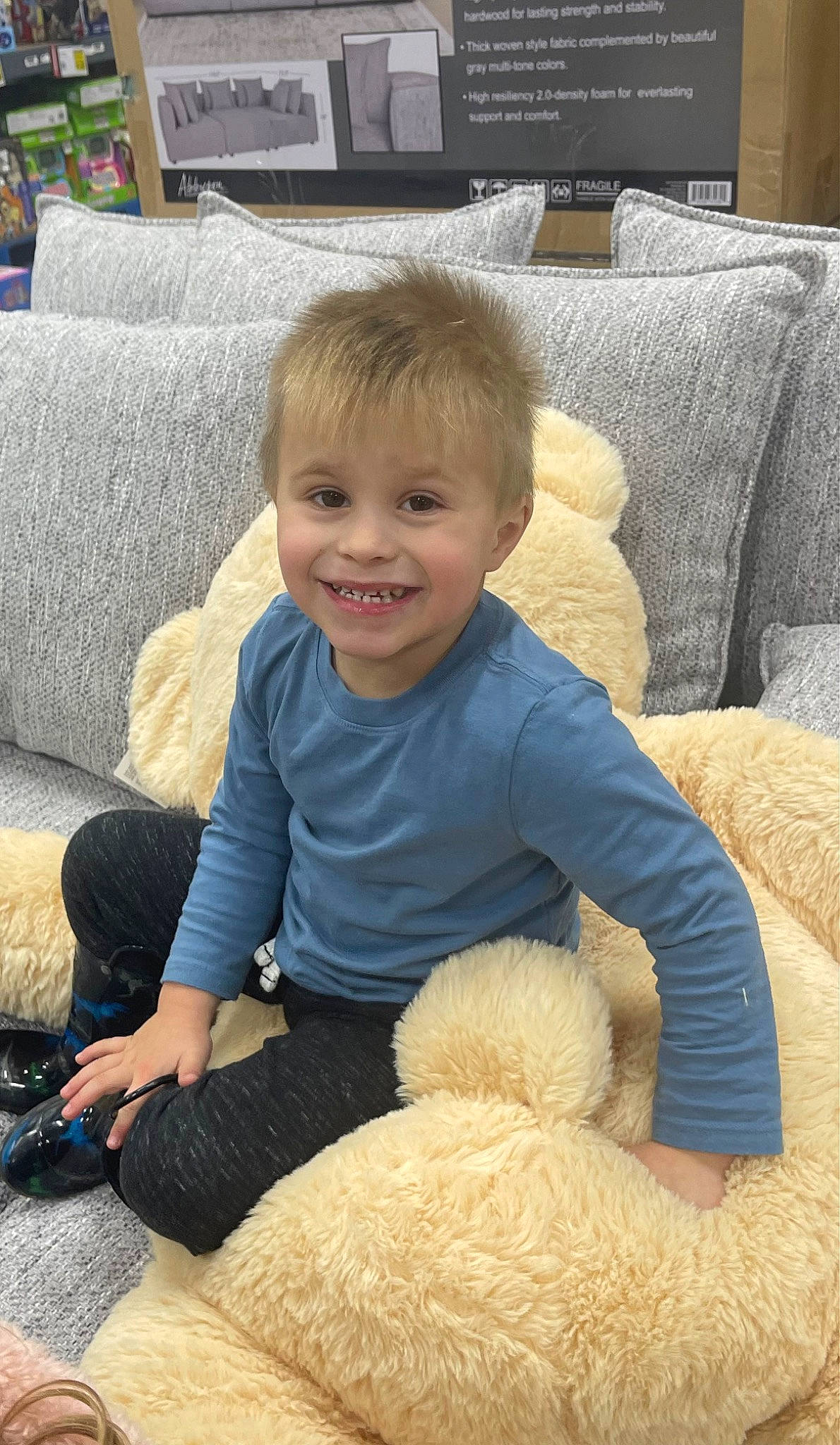 Brayden is registered to the contest to win money with this photo: baby, baby_toddler_clothing, child, comfort, couch, fur, joy, lap, living_room, person, picture_frame, pillow, room, sitting, smile, teddy_bear, television, textile, throw_pillow, toddler