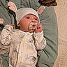 Lila joined the competition — help win amazing prizes! baby, infant, child, pacifier, bunny_hat, onesie, sleepwear, blanket, bed, lying_down, portrait, face, eyes_open, indoor, cozy, nursery, textile, stuffed_animal_print, calm, cute