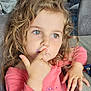 Maëlyne participe au concours pour gagner de l'argent avec cette photo : child, girl, curly_hair, green_eyes, pink_shirt, finger_on_lips, thoughtful, indoor, table, wood_surface, casual_clothing, portrait, cute, young_child, person, face, hand, seated, home, expression