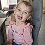 child, girl, smiling, indoor, sitting, pink_shirt, jeans, plush_toy, happy, cute, living_room, chair, curtains, couch, table, toy, person, face, hair, casual