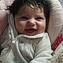 baby, smiling, infant, cozy, white_outfit, snowflake_pattern, curly_hair, baby_seat, blanket, happy, cute, child, indoors, portrait, soft_texture, warm, closeup, face, young_child, comfort