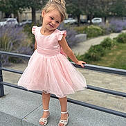 élyna participe au concours pour gagner de l'argent avec cette photo : blonde_hair, child, concrete, cute, daylight, dress, flower_bed, girl, grass, happy, outdoor, park, pink_dress, portrait, posing, railing, sandals, smiling, urban, young