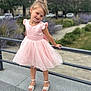 blonde_hair, child, concrete, cute, daylight, dress, flower_bed, girl, grass, happy, outdoor, park, pink_dress, portrait, posing, railing, sandals, smiling, urban, young