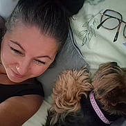 Maya a rejoint le concours — aidez-le/la à gagner de superbes lots ! woman, dog, bed, glasses, collar, relaxing, indoor, portrait, sleeping_dog, casual, closeup, smiling, hair, fabric, face, pet, resting, home, leisure, accessory