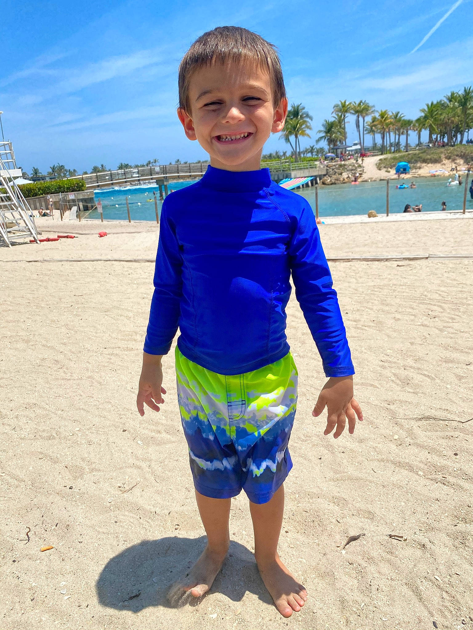 Justice is registered to the contest to win money with this photo: beach, board_short, cloud, coastal_and_oceanic_landforms, face, fun, happy, joy, leisure, natural_environment, people_on_beach, person, shore, sky, sleeve, smile, summer, t_shirt, toddler, travel