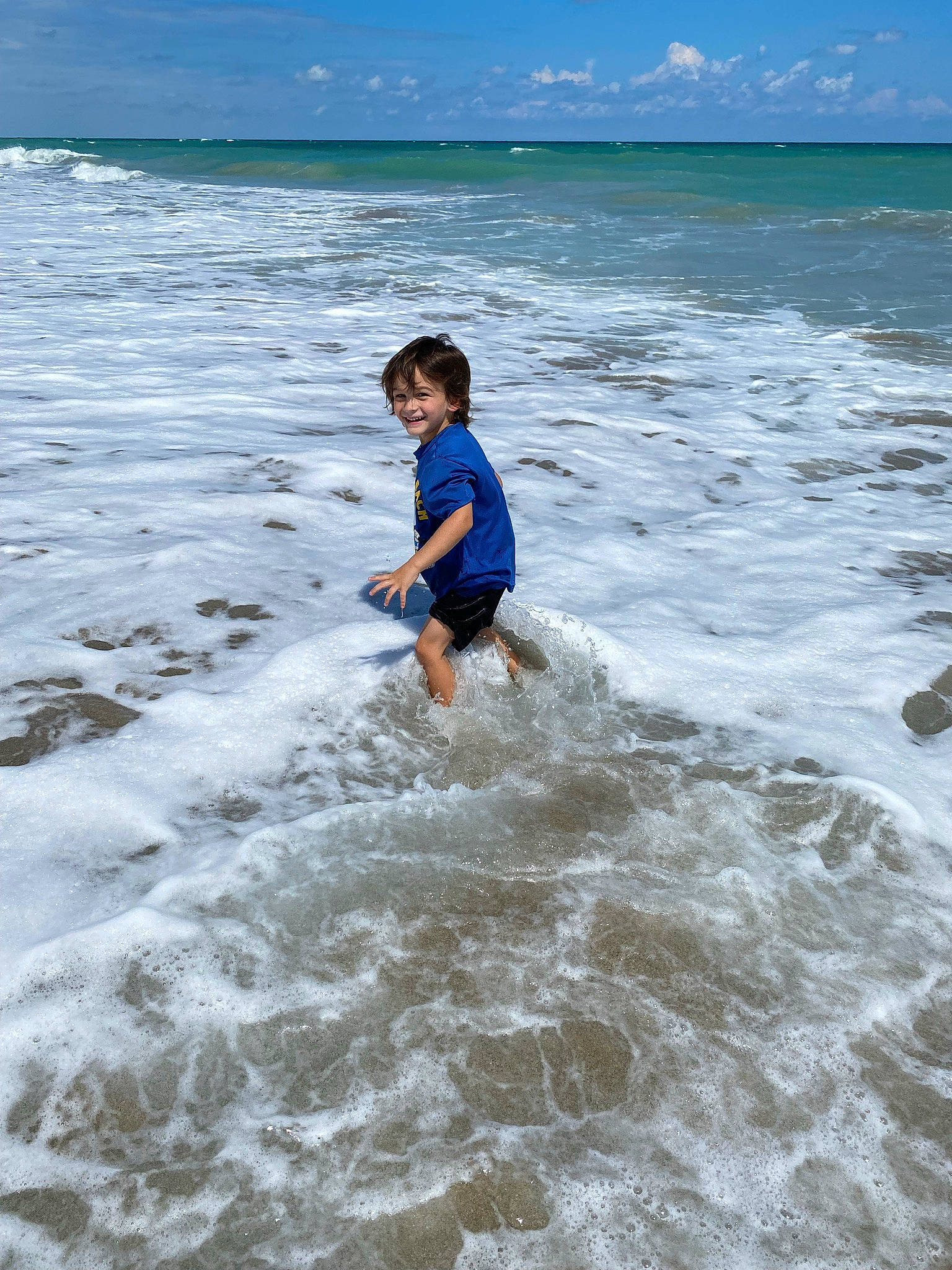 Justice is registered to the contest to win money with this photo: beach, cloud, coastal_and_oceanic_landforms, fun, happy, holiday, horizon, joy, leisure, people_on_beach, person, recreation, sand, shore, shorts, sky, smile, toddler, water, water_resources