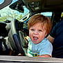 toddler, child, car, steering_wheel, interior, daylight, happy, excited, person, short_sleeves, seat, automobile, young_child, hair, smile, open_mouth, window, dashboard, seatbelt, adult_arm