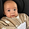 baby, infant, face, eyes, sweater, heart_pattern, blanket, cushion, seated, clothing, cute, skin, hand, portrait, child, young, indoors, comfort, warm, expression