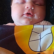 Kenleigh French joined the competition — help win amazing prizes! baby, infant, sleeping, face, portrait, blanket, wrapped, cozy, indoors, close_up, peaceful, resting, couch, textile, patterned_blanket, warm_lighting, head, closed_eyes, mouth, cute