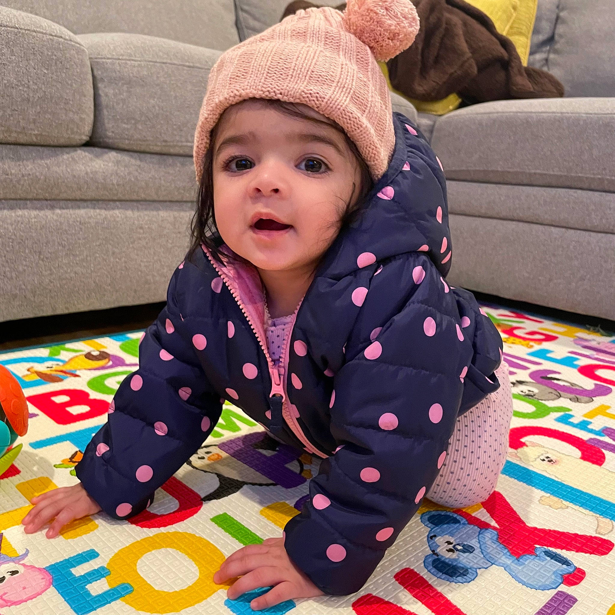 Anaya joined the competition — help win amazing prizes! baby_toddler_clothing, cap, child, comfort, cool, couch, floor, flooring, fun, happy, headwear, knit_cap, leisure, linens, pattern, person, play, sitting, sleeve, textile
