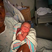 Josiah joined the competition — help win amazing prizes! newborn, baby, hospital, blanket, person, hand, hospital_gown, bed, indoor, medical, patient, furniture, curious, wrapped, skin, face, infant, holding, adult, room